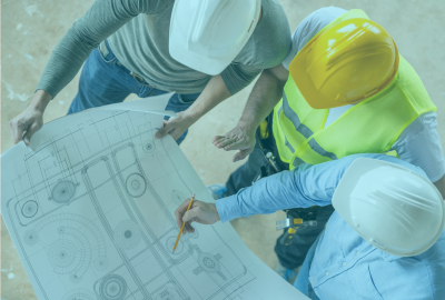 Ingenieros en protección civil y seguridad industrial revisando planos en una obra, representando la formación en prevención de riesgos y emergencias en CONAEC.