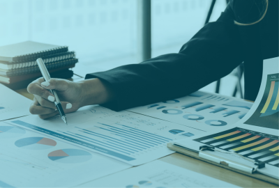 Profesional analizando informes y gráficos financieros, representando la formación en la Maestría en Administración Pública en CONAEC.